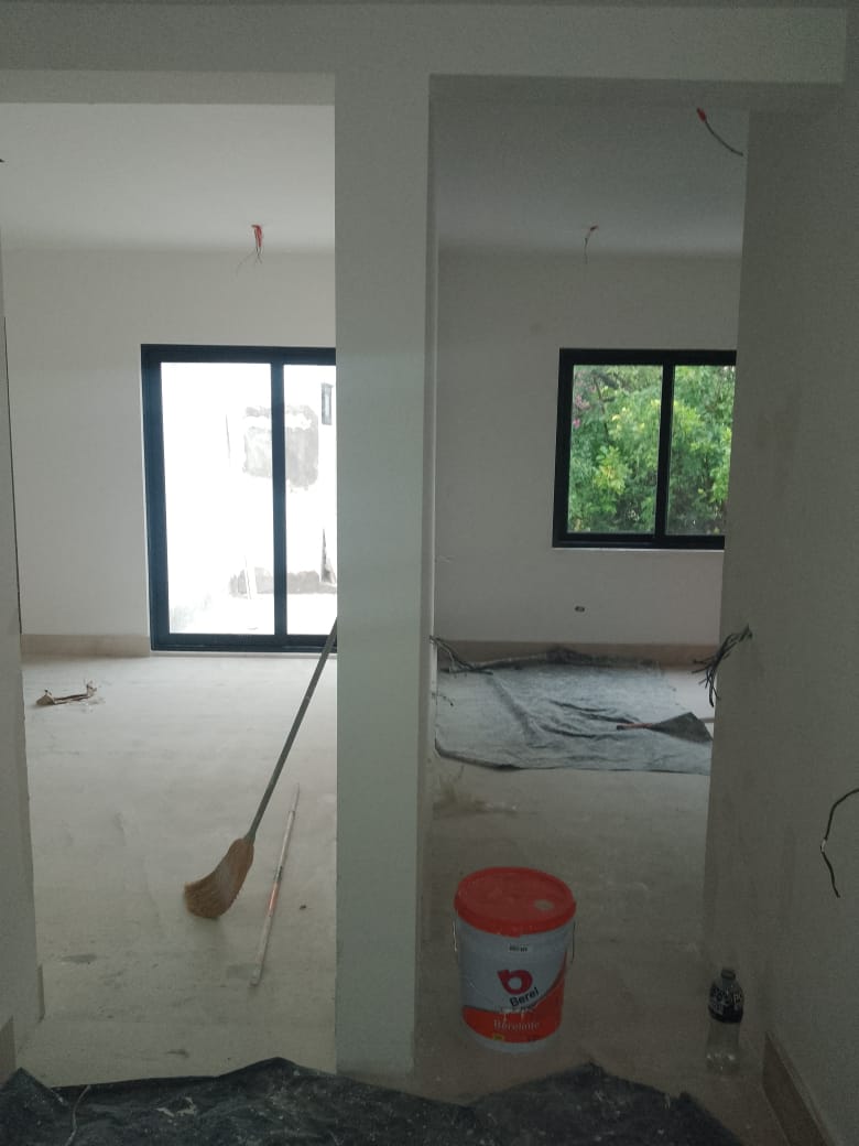 Ventanas y puerta corrediza de aluminio negro con cristal claro, integrando áreas interiores con jardín y vista al exterior.