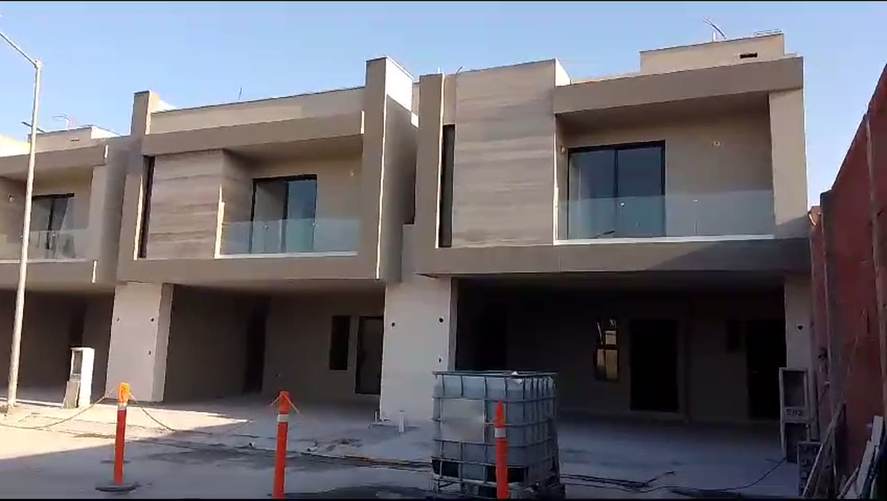 Recorrido por el fraccionamiento mostrando las residencias con cancelería de aluminio negro y barandales de cristal templado.